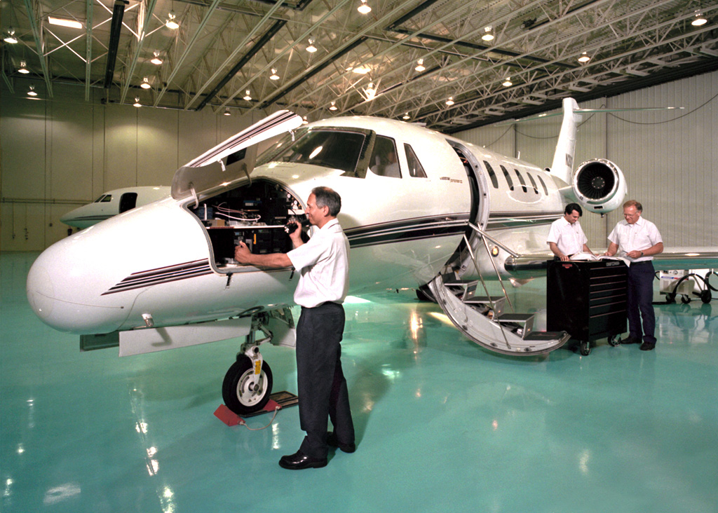 Airplane in hangar with mechanics